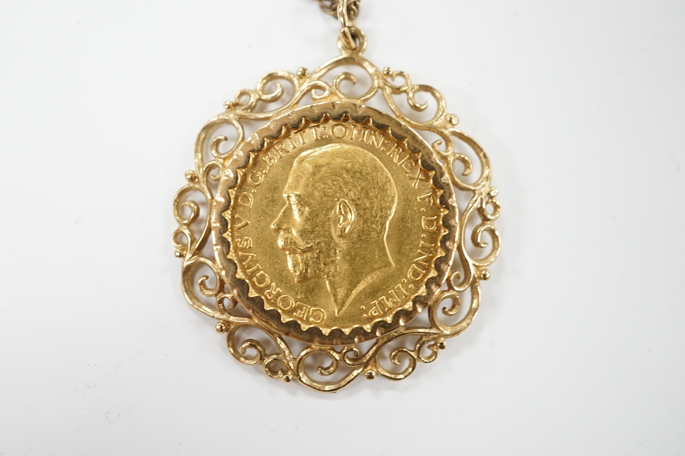 A George V gold sovereign, in a later 9ct gold pendant mount, on a 9ct chain, 63cm, gross weight 16 grams. Condition - fair